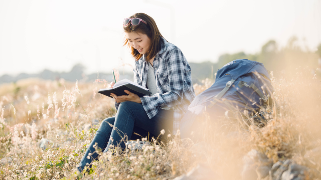 Woman writing in a journal outdoors